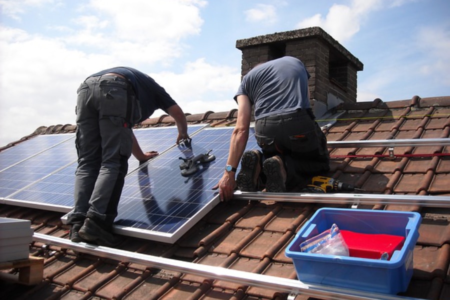 Solar company employees installing solar panels on a roof