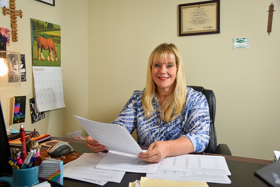 Certified Public Accountant Denise Calderon in her Minneola, Florida office smiles as she reviews paperwork and tax information